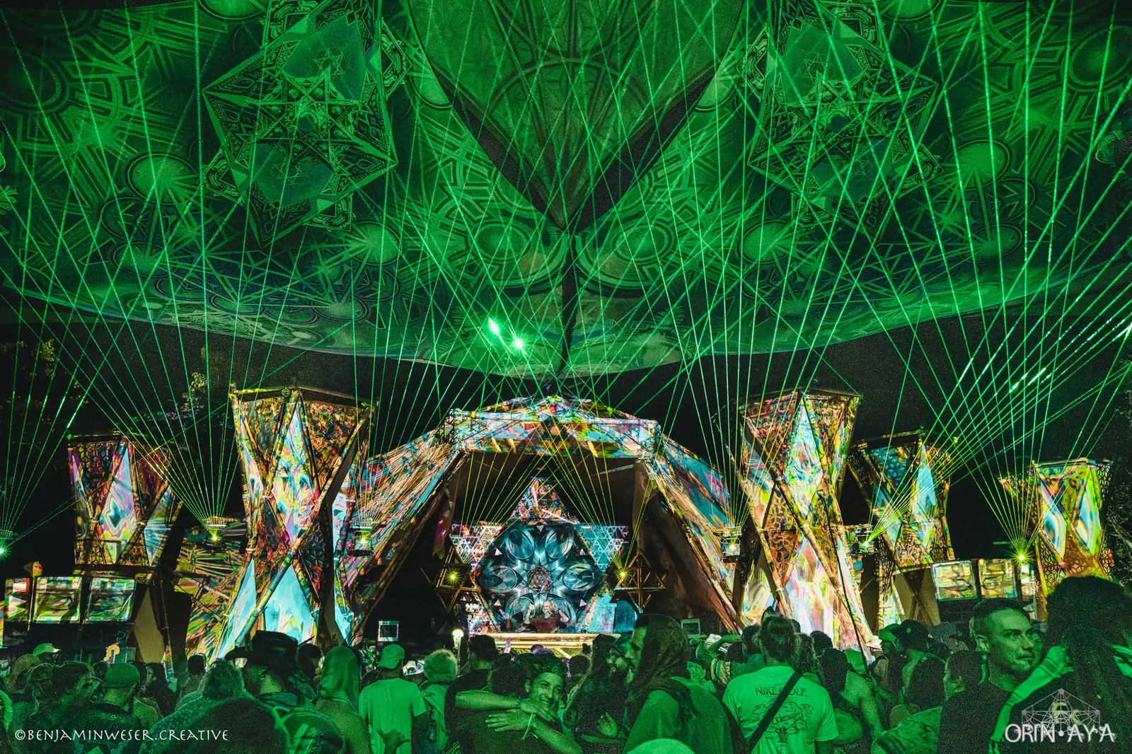 Green laser show over a festival crowd